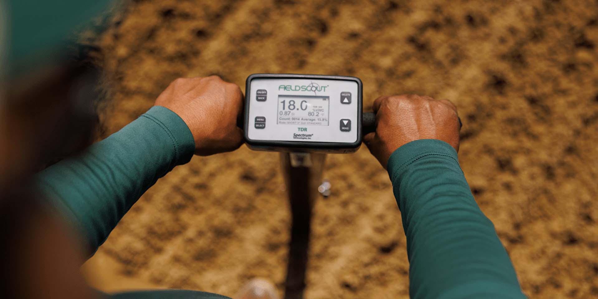 A first-person-view of a person holding a fieldscout dirt reader.