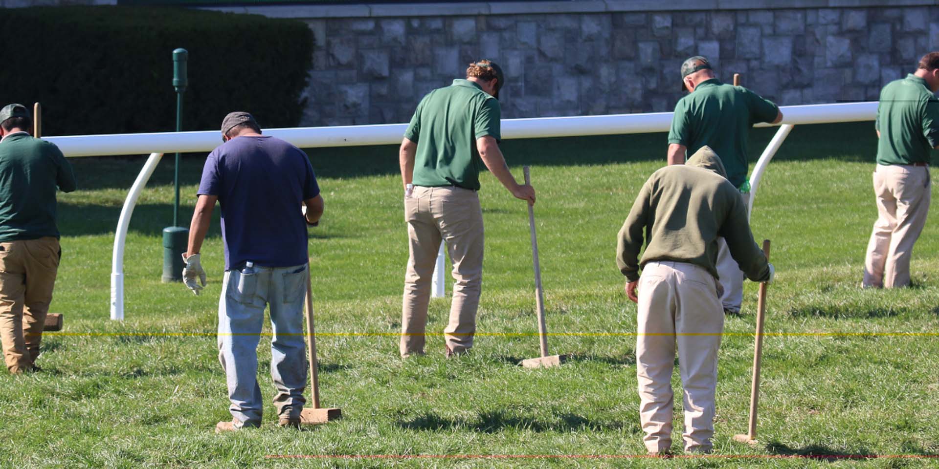 An action shot of Keencanter team members tamping down turf divots.